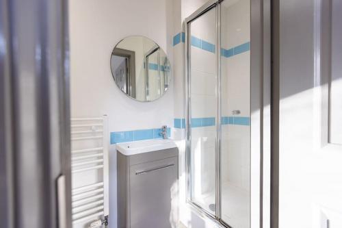 a white bathroom with a sink and a mirror at 7 Bed House Pitchford Road in Earlham