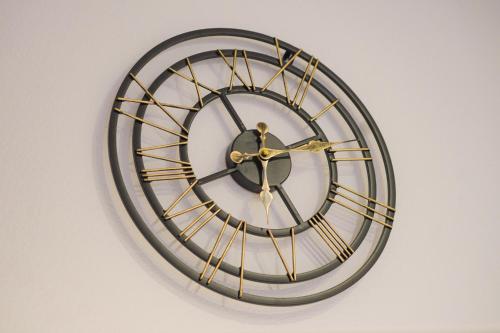 a black and gold clock on a wall at Exklusives Ferienapartment in der Papenburger Stadtmitte in Papenburg