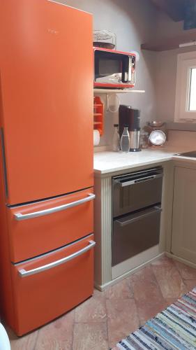 a kitchen with an orange refrigerator in a kitchen at Casetta Camilla in Varese