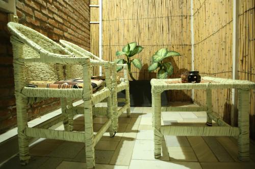 a pair of wicker chairs and a table on a balcony at Tea House BNB in Kigali