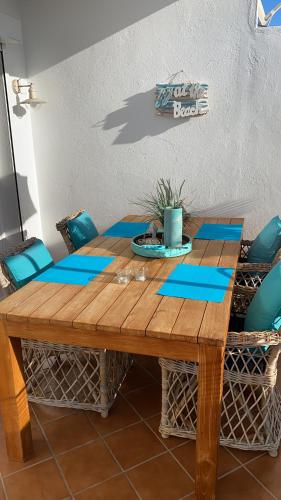 a wooden table with blue napkins on top of it at Casa BLANKA Bahia Playa Anlage Costa Calma in Costa Calma