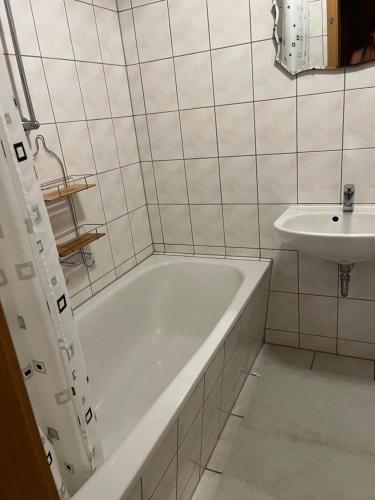 ein weißes Badezimmer mit einer Badewanne und einem Waschbecken in der Unterkunft Apartamento Plauen in Plauen