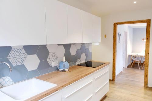 eine Küche mit weißen Schränken und einer Arbeitsplatte in der Unterkunft Appartement thématique: Nature Scandinave in Travers
