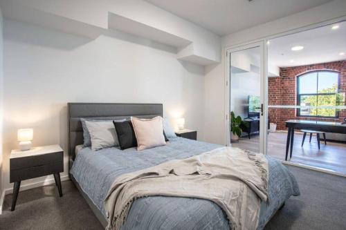 a bedroom with a large bed and a living room at Bendigo CBD Apartment in Bendigo