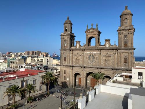 uma velha igreja com duas torres e palmeiras em Bedonbeach em Las Palmas de Gran Canaria