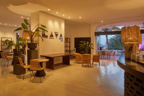a living room with chairs and a table and a dining room at Dreams Jardin Tropical Resort & Spa in Adeje