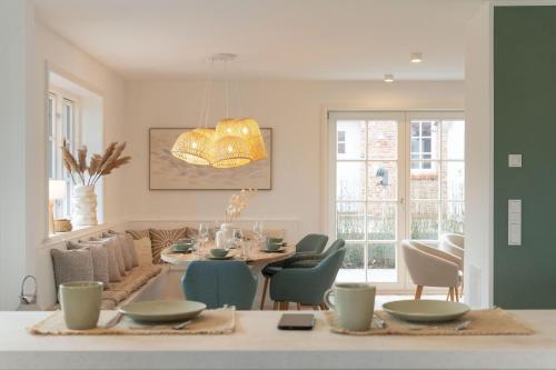 Un comedor y una sala de estar con mesa y sillas. en Landhaus John, en Oldsum