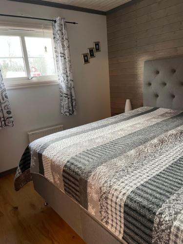 a bedroom with a bed with a blanket on it at B & B Flattinge Fritidshus in Vittaryd