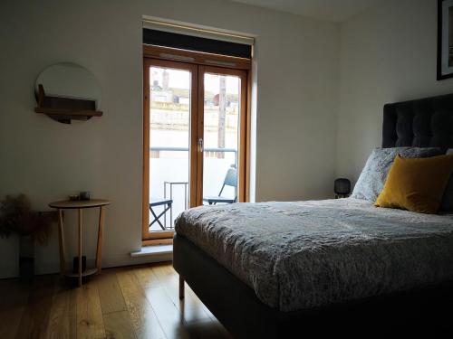 Un dormitorio con una cama y una puerta de cristal. en Beautiful central townhouse w/ parking for 2 cars, en Brighton & Hove