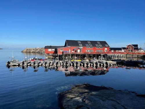 a dock with a red building on the water at Å, the far end of Lofoten. in Moskenes