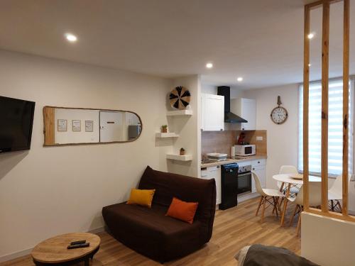 a living room with a couch and a kitchen at Appartement - Narbonne in Narbonne