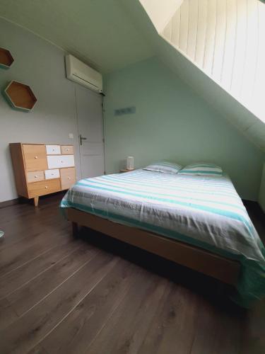 een slaapkamer met een bed en een houten vloer bij Chambres in Saint-Mars-la-Brière
