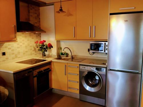 a kitchen with a stainless steel refrigerator and a dishwasher at ELILAR BAIONA in Baiona