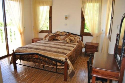 1 dormitorio con 1 cama grande en una habitación con ventanas en Sunray Villa - Luxury Villa with Private Pool, en Argaka