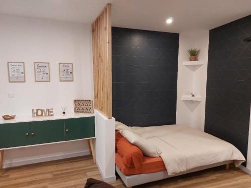 a small bedroom with a bed and a wall at Appartement - Narbonne in Narbonne