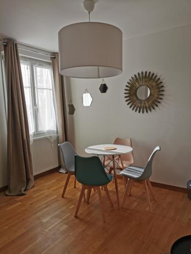 une salle à manger avec une table, des chaises et un miroir dans l'établissement Chez Arnauld, à Reims