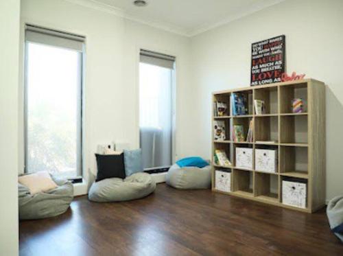a living room with two bean bags and a book shelf at Little Bluebird Kuranjang 31min drive to MEL airport in Melton