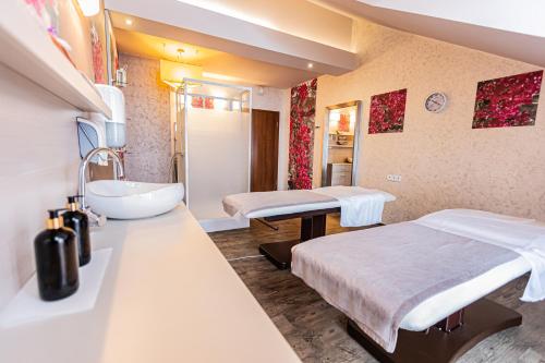 una camera ospedaliera con due letti e un lavandino di Hotel Olivia Medical SPA a Skomielna Czarna