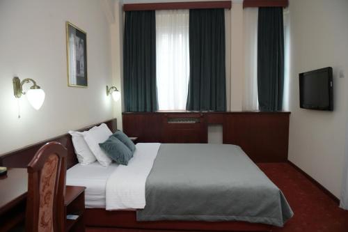 a hotel room with a bed and a television at Palace Hotel in Belgrade