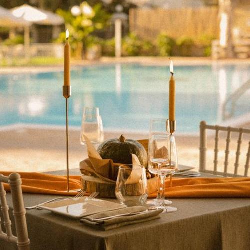 a table with wine glasses and a pumpkin on it at La Pineta Dei Liberti in Lido dei Pini