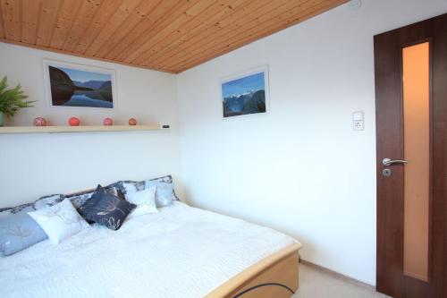 - une chambre avec un lit et un plafond en bois dans l'établissement Untersee24 - Lake Hallstatt Apartment, à Bad Goisern