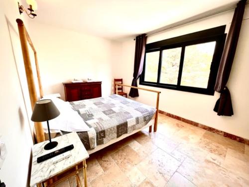 um quarto com uma cama, uma mesa e uma janela em Grand appartement en face du village em Moustiers-Sainte-Marie