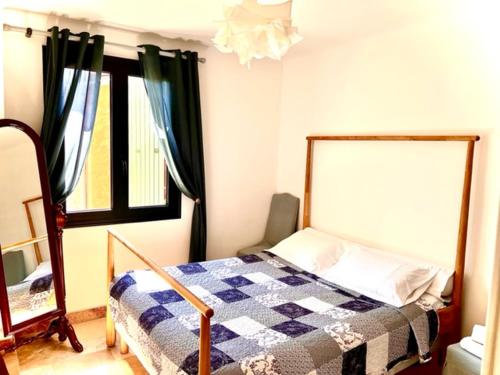 a bedroom with a bed with a checkered blanket at Grand appartement en face du village in Moustiers-Sainte-Marie