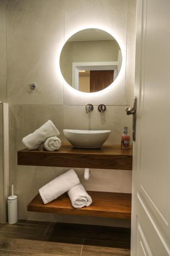 a bathroom with a sink and a mirror at Heaven Apartments in Agia Marina Nea Kydonias