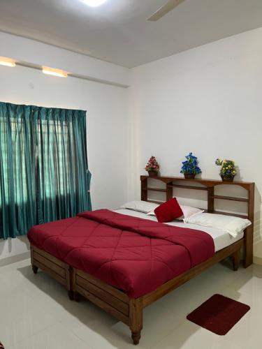 a bedroom with a large bed with a red blanket at Wind Valley in Ramakkalmedu