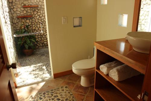 y baño con aseo y lavamanos. en Coral Beach Village Resort, en Utila