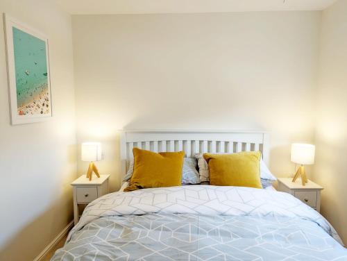 a bedroom with a bed with yellow pillows and two lamps at Cabane Mont Fort in East Wittering