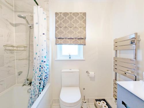 a white bathroom with a toilet and a shower at Cabane Mont Fort in East Wittering