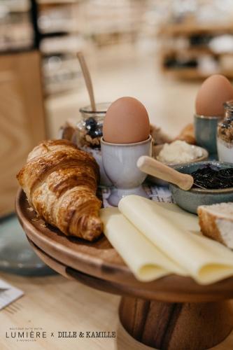 a tray of food with eggs and croissants on a table at Boutique Hotel Lumiere in Eindhoven