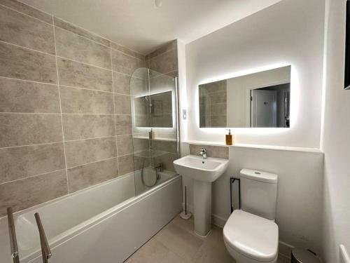 a bathroom with a sink and a toilet and a tub at Hömli Close2City Apartment in Faygate