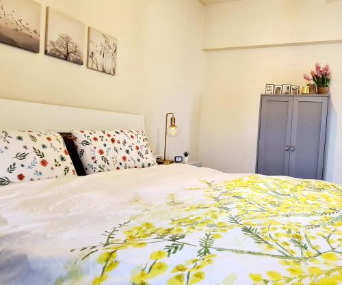 1 dormitorio con 1 cama con manta amarilla y blanca en מול הים - בית נופש עם ממ"ד ומרפסת עם נוף פנורמי לים en Moreshet