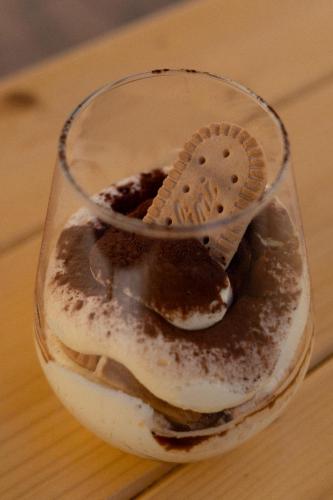 a glass jar with a cookie on top of a dessert at La Pineta Dei Liberti in Lido dei Pini