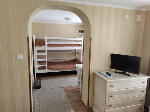 a room with two bunk beds and a television at Самостоятелна Вила в Хаджи Марковата къща за гости в Дряново in Dryanovo