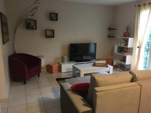 uma sala de estar com um sofá e uma televisão em centre Pierrefonds superbe appartement + parking em Pierrefonds