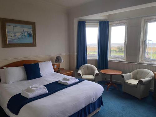 a hotel room with a bed and two chairs at Clarkes Hotel Barrow in Furness in Barrow in Furness