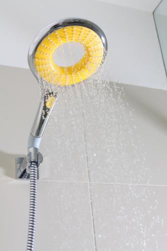 a shower head with water coming out of it at Bloom Hotel - Golf Course Road, Sector 43 in Gurgaon
