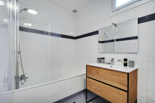 ein Badezimmer mit Waschbecken und Dusche in der Unterkunft Grand Appartement aux Portes de Paris in Aubervilliers