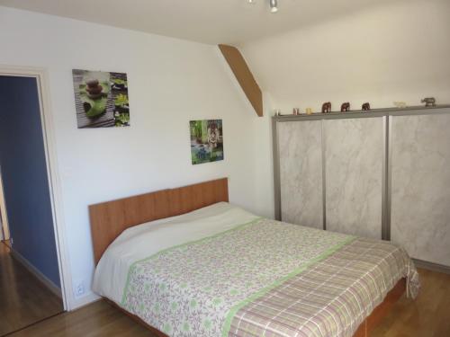 ein kleines Schlafzimmer mit einem Bett und einem Schrank in der Unterkunft TY Lavarion in Le Bono