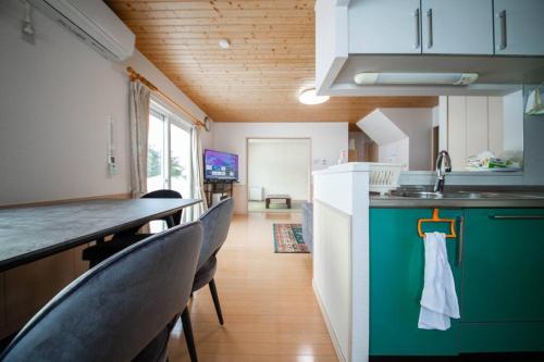 a kitchen with chairs and a counter with a sink at The Sanfurano in Kami-furano
