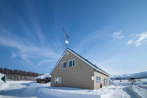 a building with a antenna on top of it in the snow at The Sanfurano in Kami-furano