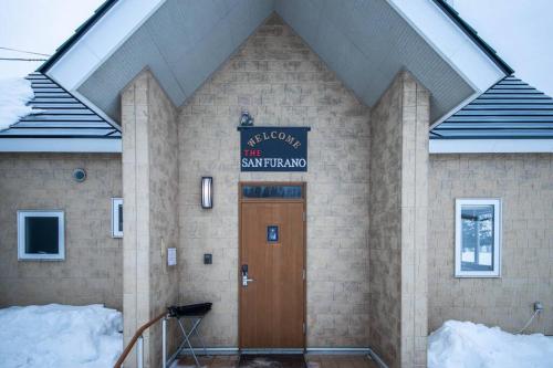 a building with a door and a sign on it at The Sanfurano in Kami-furano