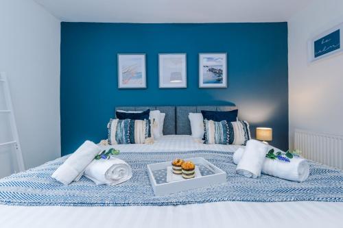 sypialnia z dużym łóżkiem z niebieską ścianą w obiekcie Stylish 2-Bed City-Centre Home in Chester by 53 Degrees Property - Ideal for Couples & Groups - Sleeps 6 w mieście Chester