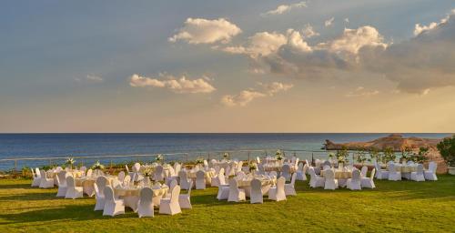 a group of tables and chairs in front of the ocean at Park Regency Sharm El Sheikh Resort in Sharm El Sheikh