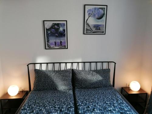sypialnia z 3 zdjęciami na ścianie nad łóżkiem w obiekcie Apartma Pr Urarj w mieście Kobarid