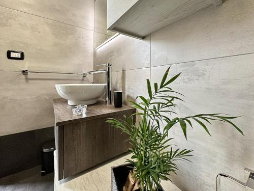 a bathroom with a sink and a potted plant at Marbel Suite in Adelfia