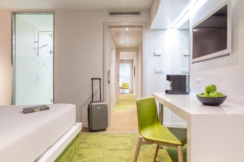 a kitchen with a desk and a green chair in a room at Hotel Macià Granada Five Senses Rooms & Suites in Granada